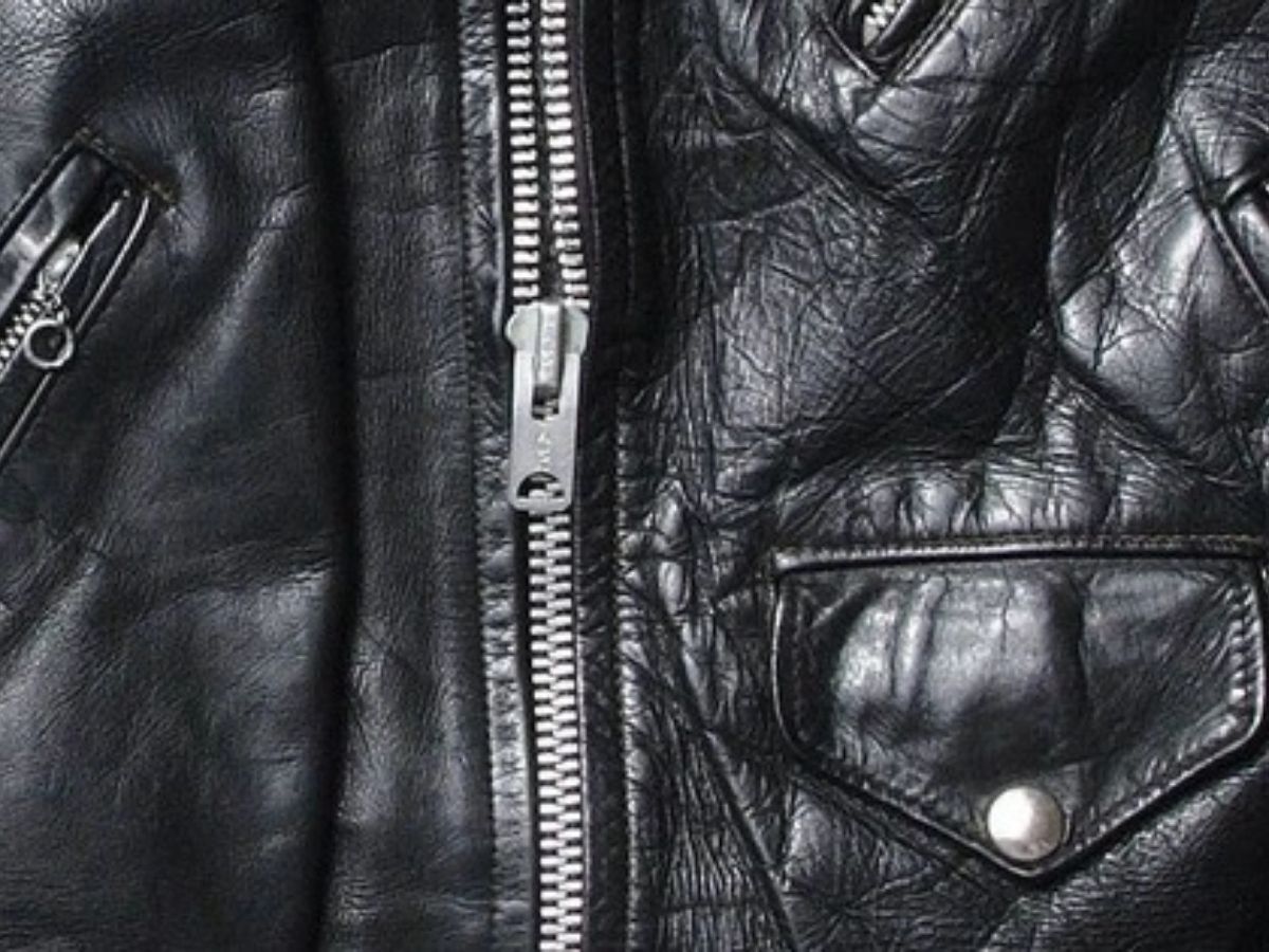 Cận cảnh khóa kéo YKK và đường may tỉ mỉ trên một chiếc áo khoác da