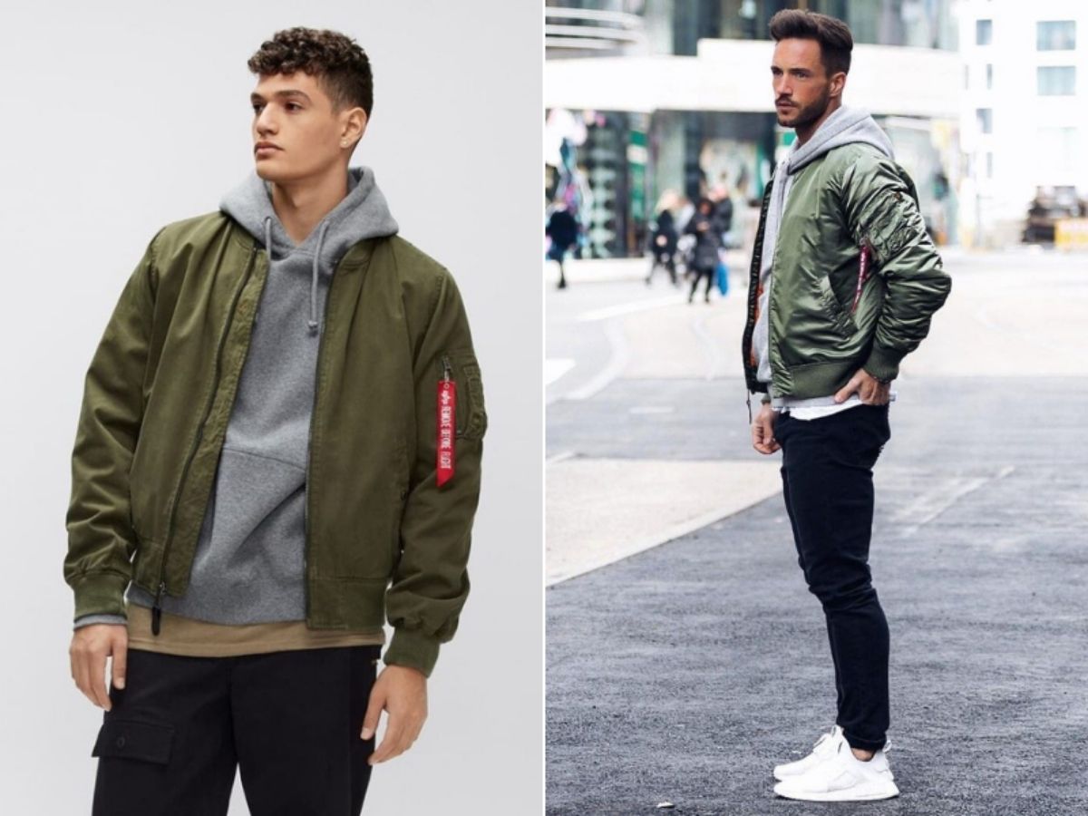 Người mẫu nam mặc áo khoác dù layer với hoodie xám bên trong, phần mũ hoodie để ra ngoài áo khoác