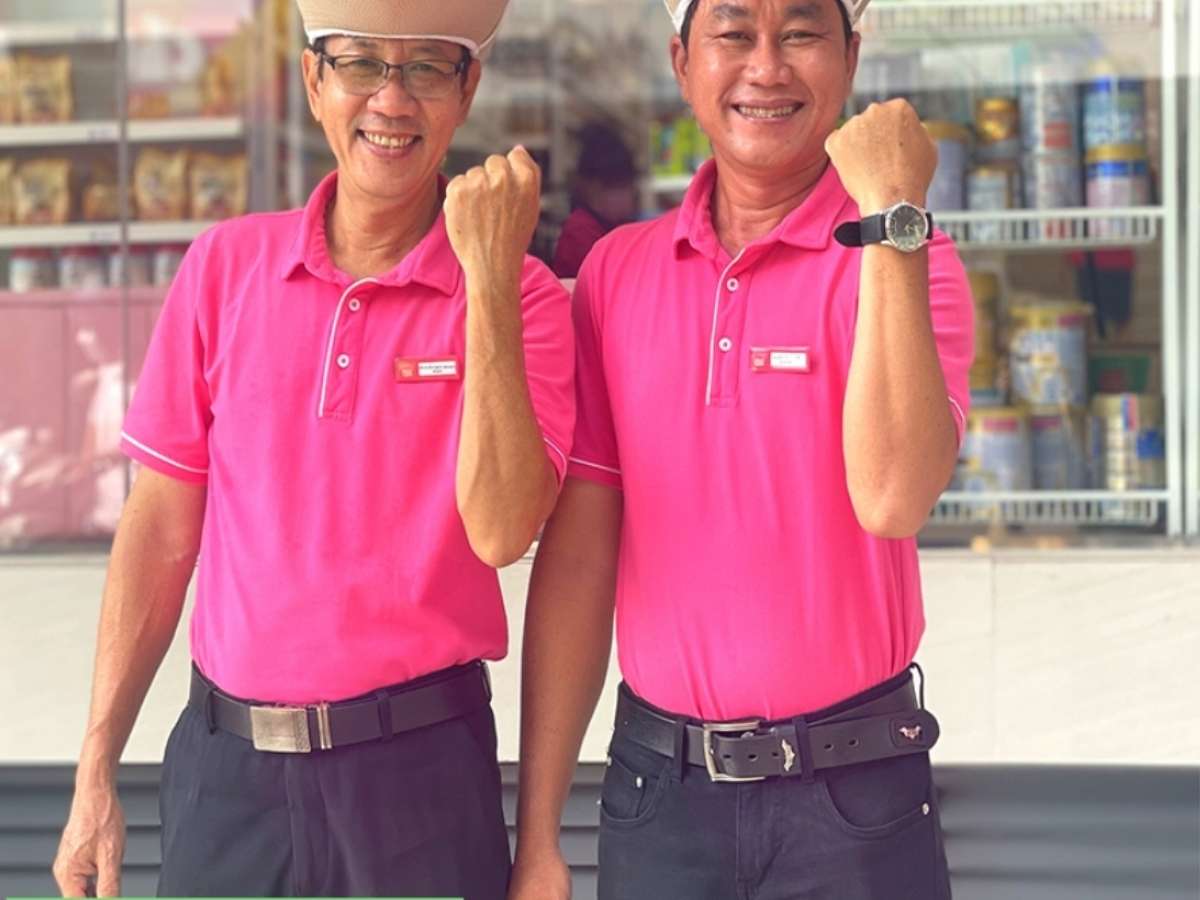 Nhân viên nam Con Cưng mặc đồng phục áo polo, thần thái tự tin, năng động