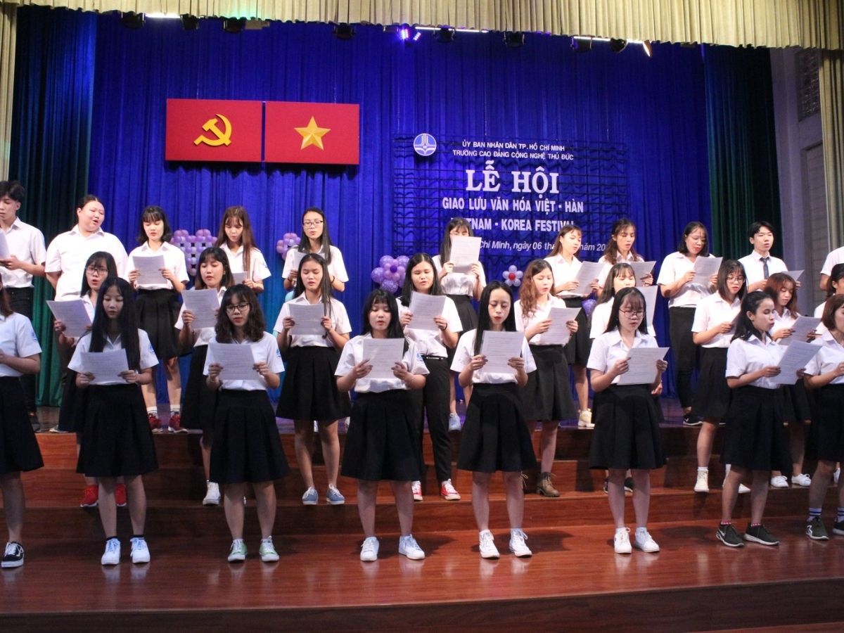 Sinh viên nam và nữ mặc đồng phục áo sơ mi trắng, nam quần tây xanh đen nữ váy TDC, thần thái tự tin, năng động