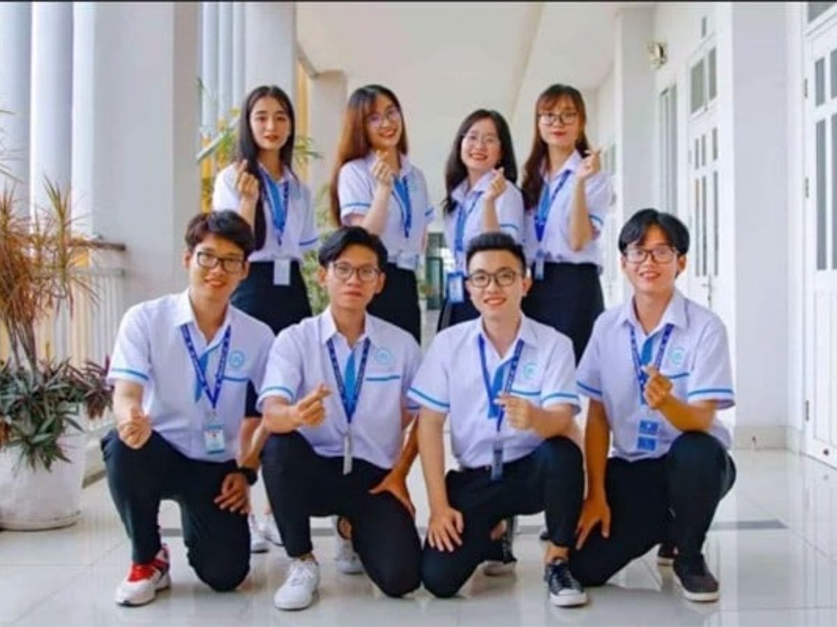 Sinh viên nam và nữ mặc đồng phục sơ mi Đại học Kinh tế trong giảng đường