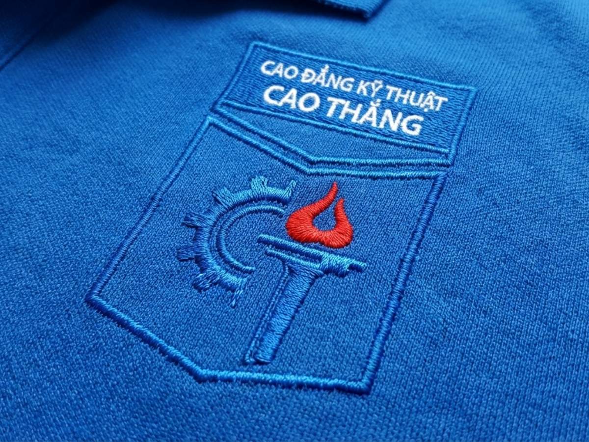 Cận cảnh logo trường Cao Thắng thêu trên ngực áo polo xanh